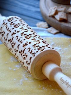 a wooden rolling pin sitting on top of a floured counter next to some food