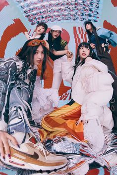 four young women posing in front of a colorful background