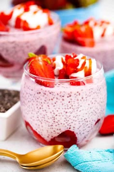 two bowls filled with fruit and yogurt on top of a table next to spoons