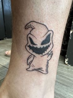 a small tattoo on the ankle of a person with an evil looking face and mouth