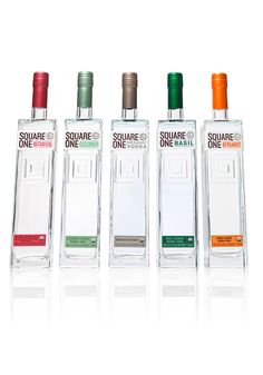 four bottles of square one vodka are lined up against a white background with the same bottle in different colors