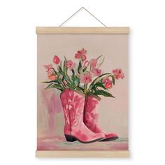 a painting of pink boots with flowers in them hanging on a wooden frame against a wall