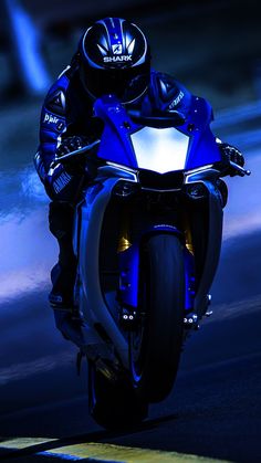 a man riding on the back of a blue motorcycle