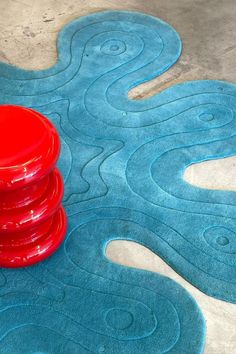 a red frisbee sitting on top of a blue rug in the middle of a floor