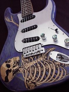 an electric guitar with skeleton artwork on it