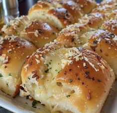 rolls covered in cheese and parmesan sprinkles on a white plate