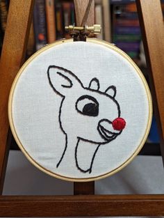 a hand embroidered deer with a red nose