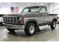 an old gray truck parked in a garage