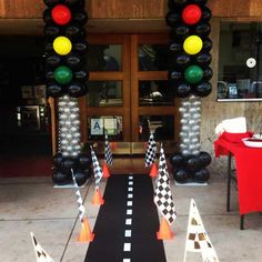 a black and white checkered road with traffic lights in front of an entrance to a restaurant