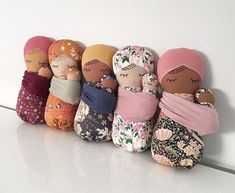 the dolls are lined up against the wall with their heads wrapped in blankets and scarves