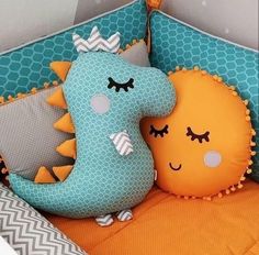 two stuffed animals sitting on top of pillows in a crib