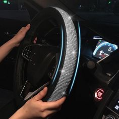 a person is holding the steering wheel cover in their car, while it's illuminated