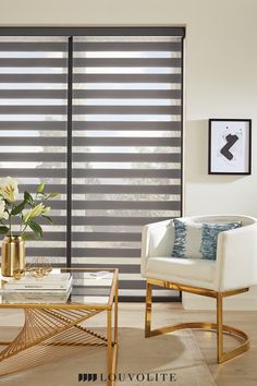 a living room with two white chairs and a coffee table in front of the window