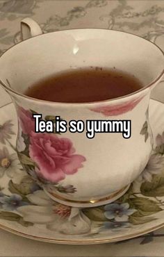 a tea cup with the words tea is so yummy on it sitting on a saucer