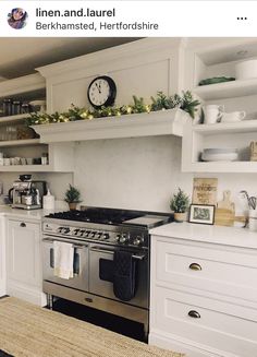 a kitchen with white cabinets and open shelving above the stove is decorated for christmas