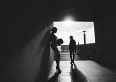 two people standing next to each other in a tunnel with the sun shining down on them