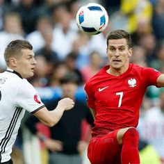 two men are playing soccer in front of an audience