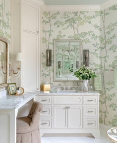 a white bathroom with floral wallpaper and chandelier