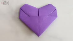 an origami heart shaped object sitting on top of a table