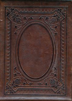 an old leather book with ornate designs on the cover