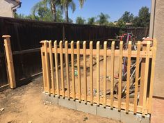 a wooden fence in front of a house with a bike parked on the other side