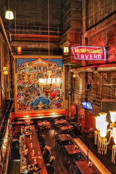 the inside of a restaurant with wooden tables and chairs, large murals on the wall