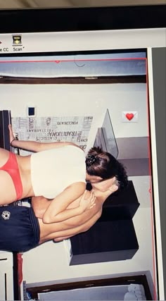 a woman in a red and white bathing suit leaning against a wall with her back to the camera