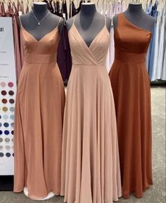 three bridesmaid dresses are on display at the bridal shop, one is peach