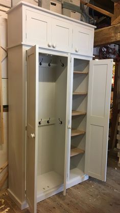 a white cabinet with two doors and shelves in a room that is being built into the wall