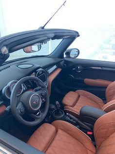 the interior of a sports car with brown leather and black trims is seen in this image