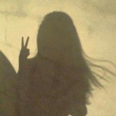 the shadow of a woman making a peace sign