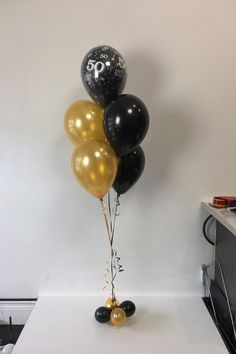 some black and gold balloons are on a table