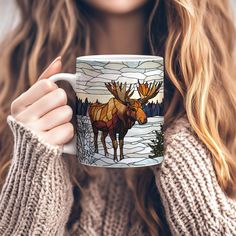 a woman holding a coffee mug with an image of a moose