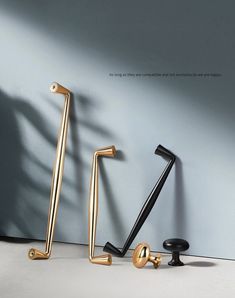 three black and gold handles on a gray wall