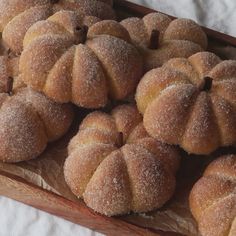 some sugared buns are on a wooden tray