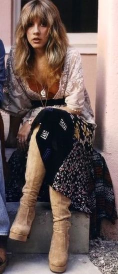 a woman sitting on the steps next to a man wearing cowboy boots and a dress