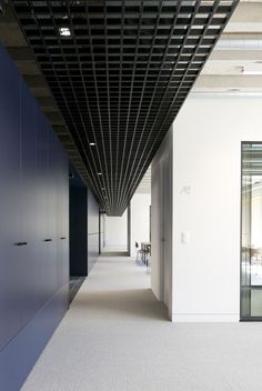 an empty hallway with white walls and black ceiling