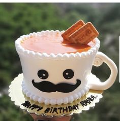 there is a cake with a mustache on it that looks like a cupcake and some crackers sticking out of it