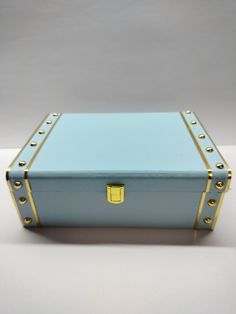 a blue and gold suitcase sitting on top of a white table