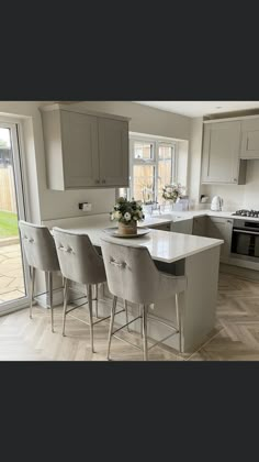 a kitchen with an island and chairs in it