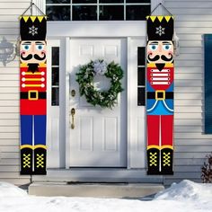 two christmas nutcrackers are standing in front of a white door with wreath