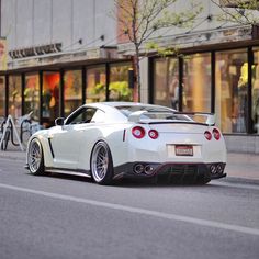 a white sports car is parked on the street