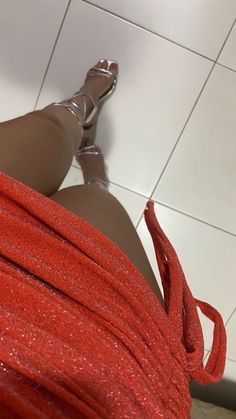 a woman's legs and red dress on the floor