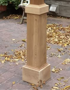 a tall wooden clock tower sitting on top of a sidewalk