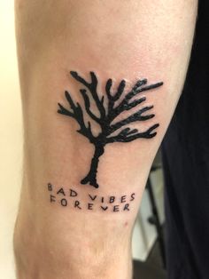 a man with a tattoo on his leg that says bad vibes forever and a tree