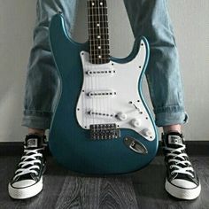 a black and white photo of a person sitting with an electric guitar in their lap