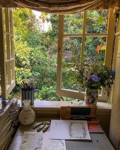 an open window in a room filled with lots of plants and papers on the table