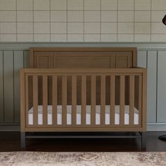 a baby crib in the corner of a room next to a lamp and rug