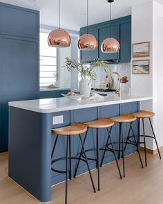 a kitchen with blue cabinets and bar stools