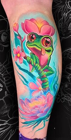 a colorful tattoo on the leg of a woman with flowers and a frog in it